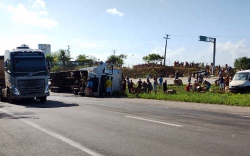 Carreta que transportava biscoitos tomba e populares saqueiam carga