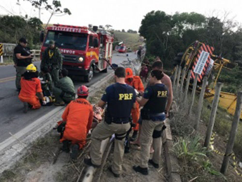 Carreta-baú tomba e condutor fica preso às ferragens na BR-101