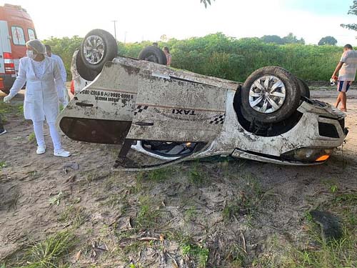 Mulher morre e jovem fica ferido após capotamento de táxi na BR-101
