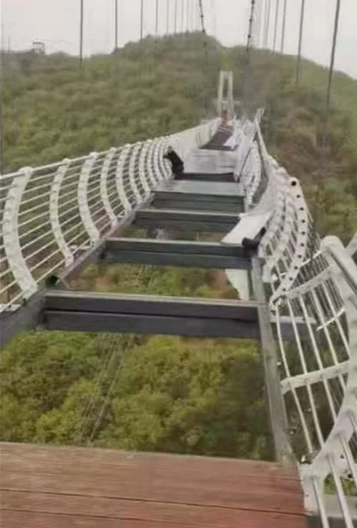 Turista fica preso a 100 metros de altura após ventania quebrar ponte de vidro na China